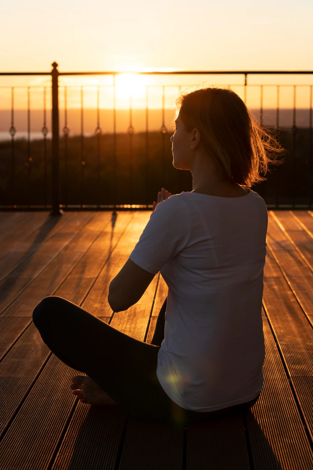 Woman practising mindful meditation outdoors at sunset