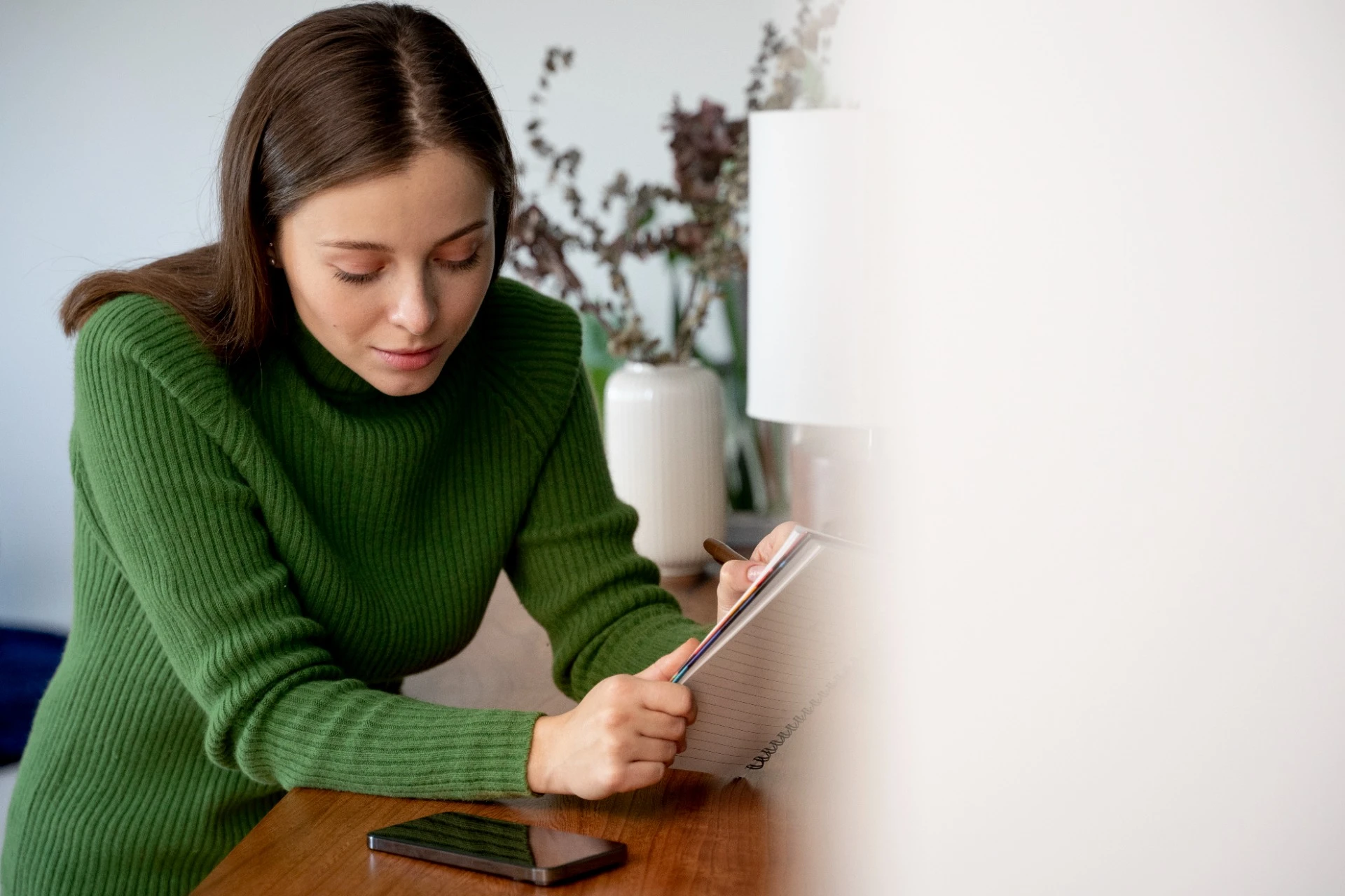 Woman using a money mindset journal to review financial goals